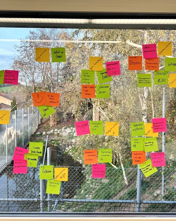 Post-its an einer Fensterfront mit Blick ins Grüne