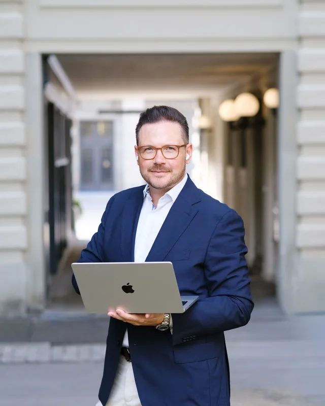 Oliver Gabor mit Laptop in einem Torbogen in Zürich